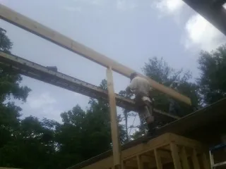 Carpenter setting a ridge beam over a new addition frame — Ice Dam Removal by Roofing Brothers in Laguna